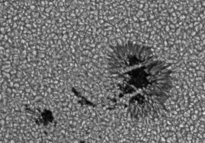 Telescopic photograph of sun granules and dark sun spots